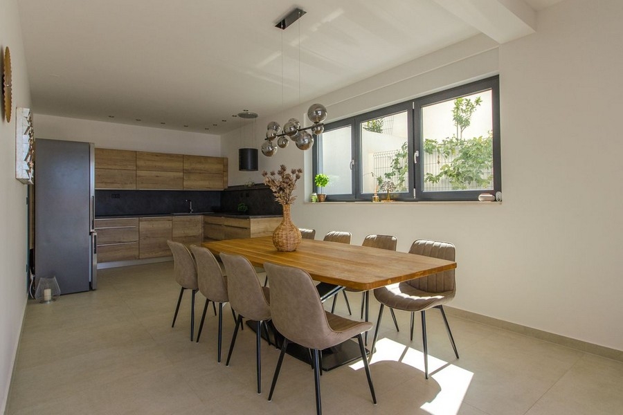 Dining area with large wooden table and modern lighting