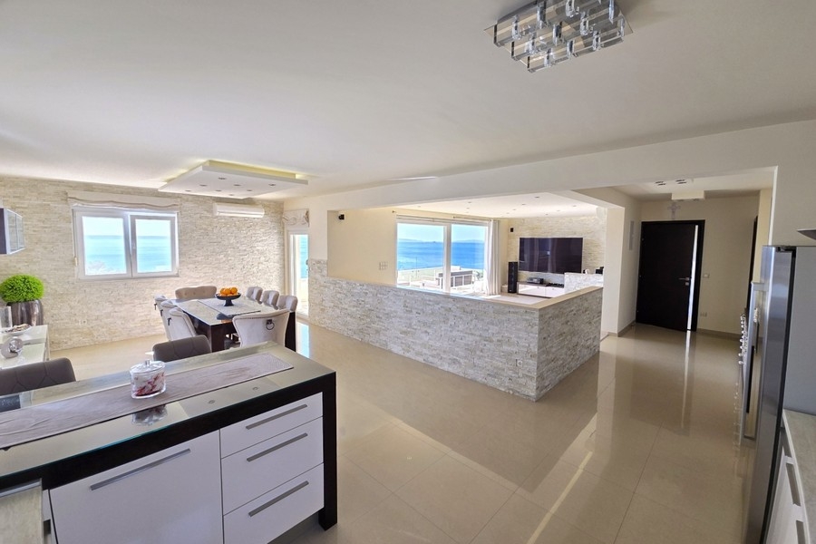 Living area with dining area and panoramic window facing the sea