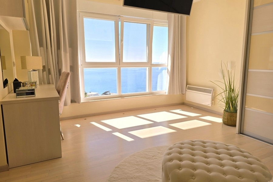 Bedroom with large window and sea view