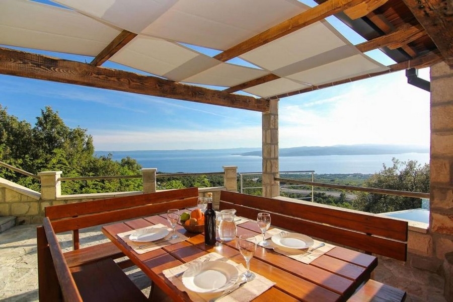 Covered terrace with seating area and sea views