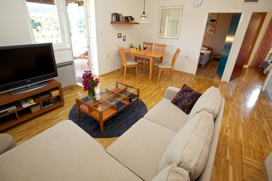 Living room with sofa, wooden floor and dining area