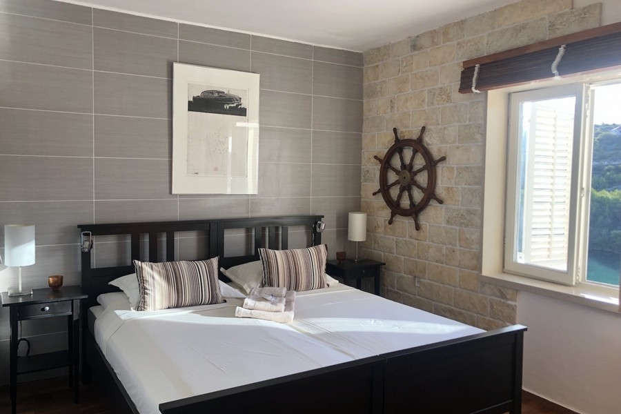 Bedroom with stone wall and sea view window