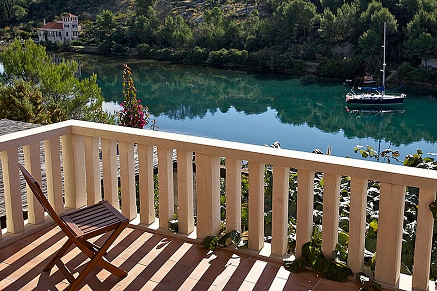 Balcony overlooking quiet bay and sailboat