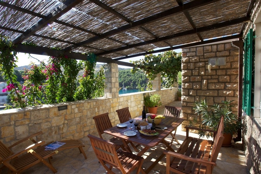 Covered natural stone terrace with seating area