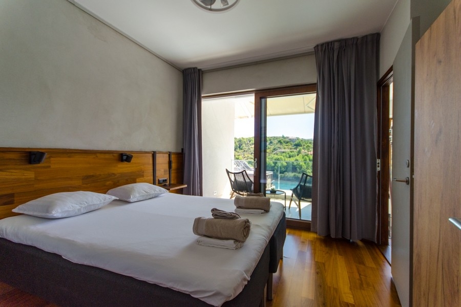 Bedroom with balcony and view of the greenery