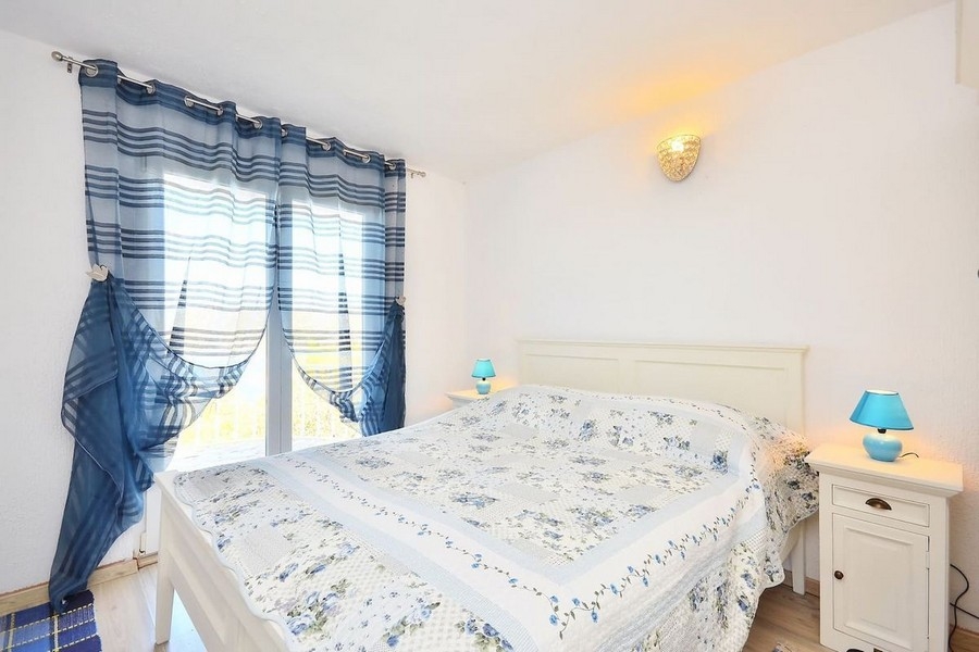 Bedroom with double bed and blue curtains