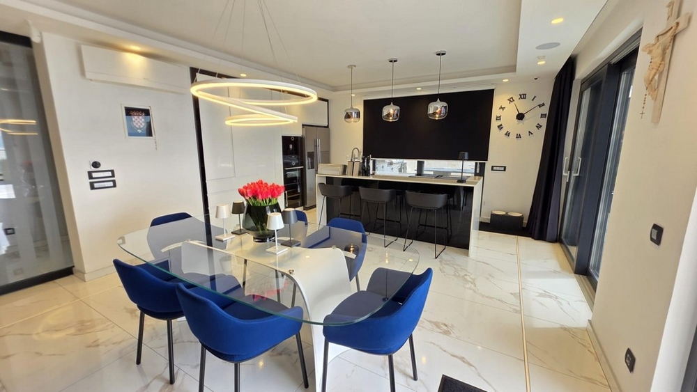 Dining area with glass table and modern kitchen