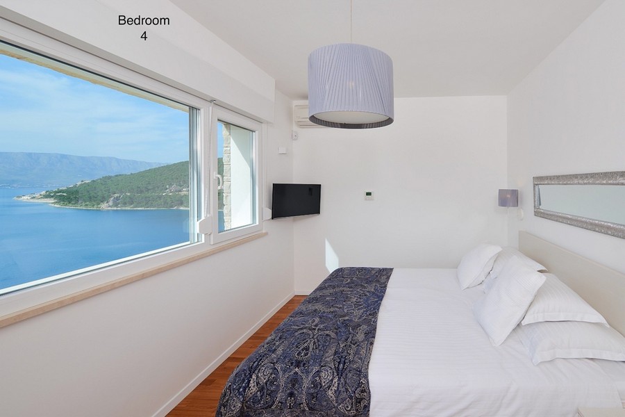Bedroom with panoramic window and sea and island views