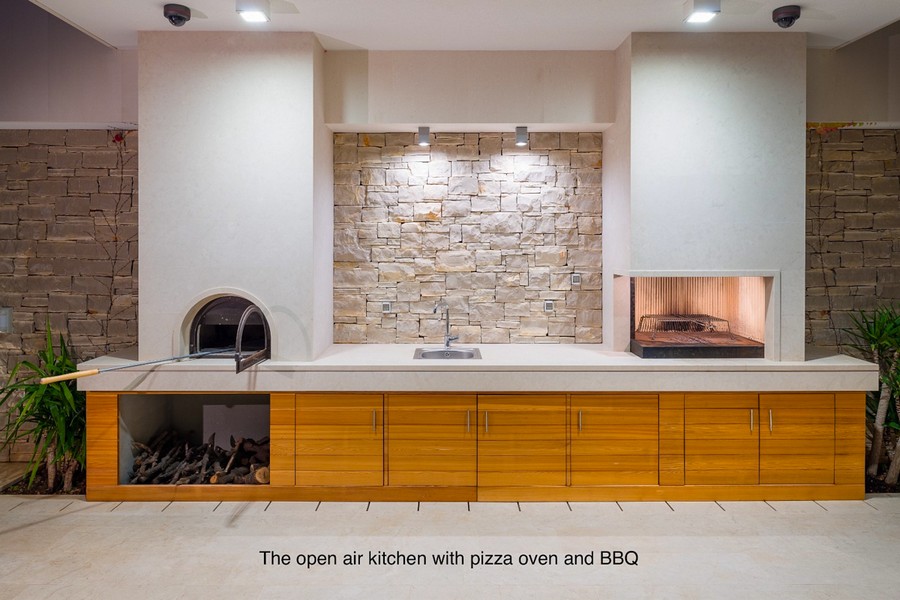 Outdoor kitchen with pizza oven, grill and work surface