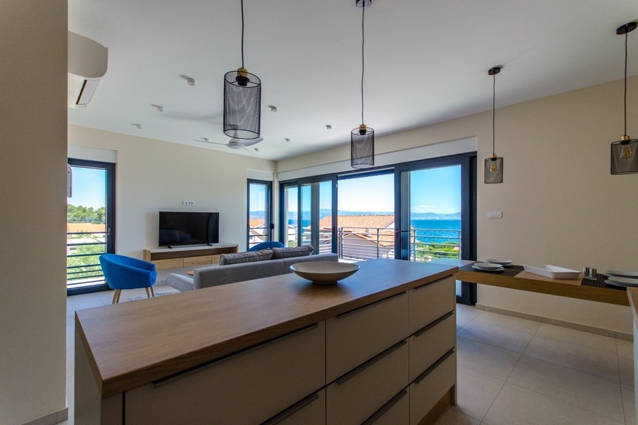 Open living and kitchen area with sea views and large glass fronts