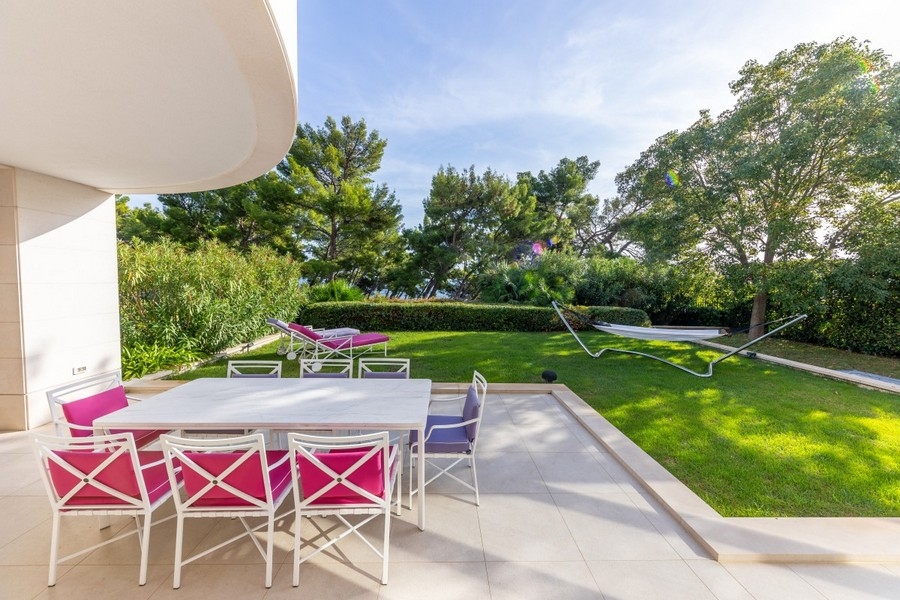 Terrace with dining table and well-kept garden of the villa