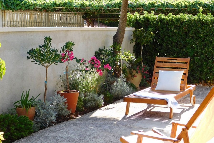 Terrace with deck chair and Mediterranean plants in the garden