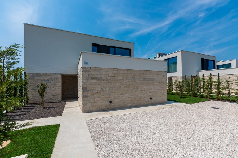 Modern villa with natural stone facade and parking spaces