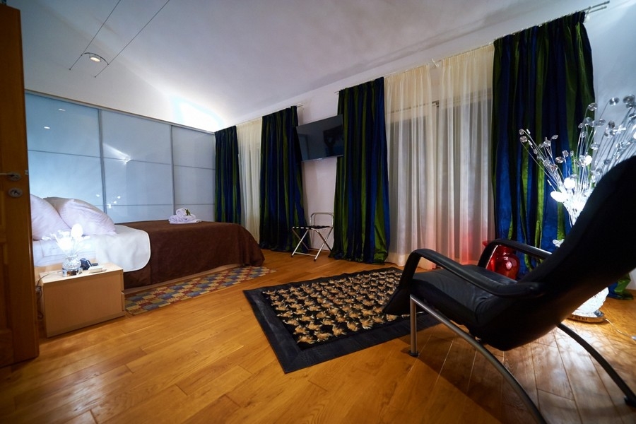 Spacious bedroom with parquet floors and seating area