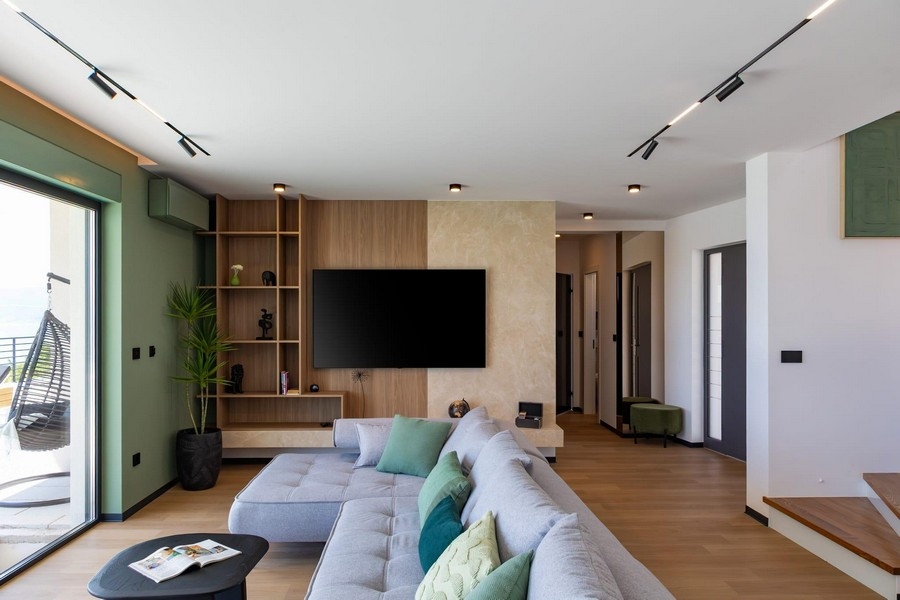 Open living area with TV wall and designer staircase