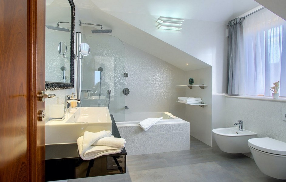 Bathroom with bathtub, shower and sloping ceiling