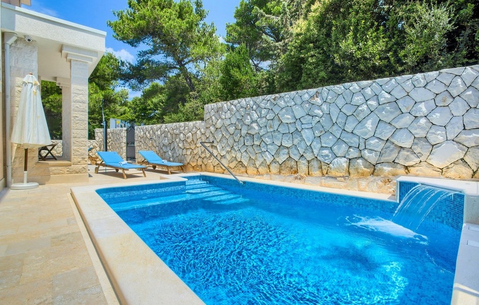 Swimming pool with sun terrace and natural stone wall