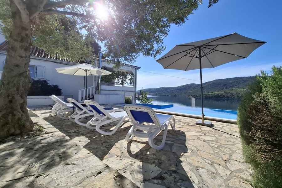 Pool area with parasols and loungers by the water