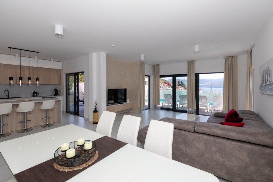 Open plan living area with kitchen and sea views through large windows