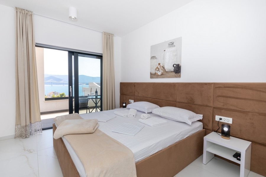 Bedroom with double bed and balcony with sea views
