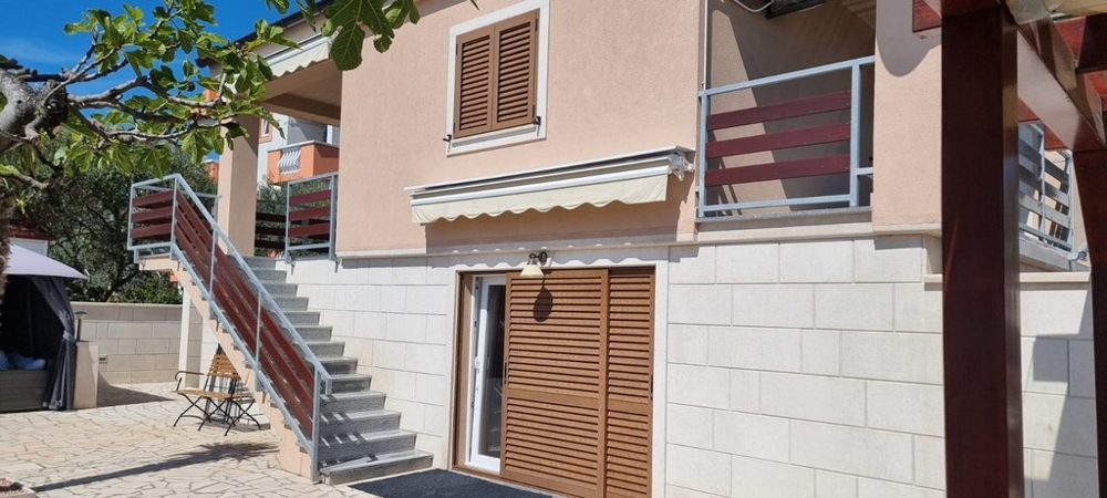 House facade with balcony, awnings and separate entrances to the residential units