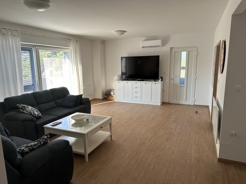 Living room with sofa, TV and access to the balcony with modern furnishings