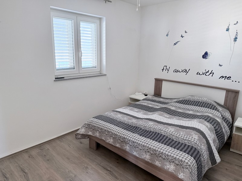 Bedroom with double bed and window in a quiet location on the island of Pag