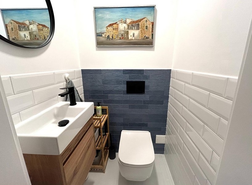 Separate toilet with sink and wall tiles