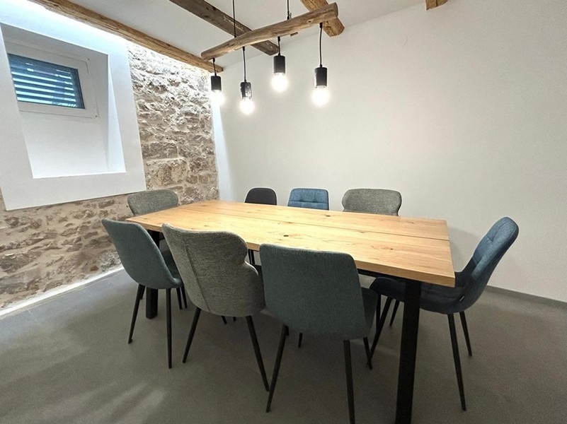 Indoor covered dining area with wooden beams and lighting