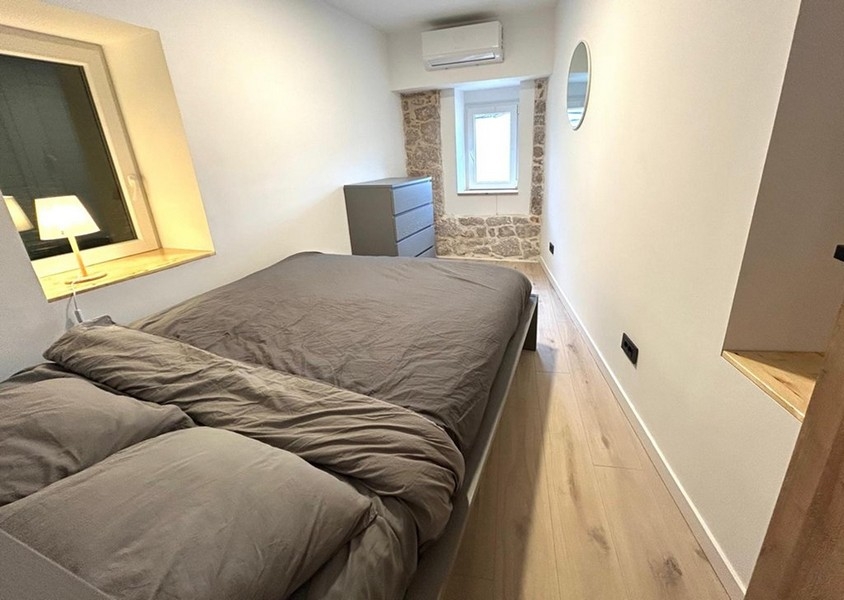 Bedroom with double bed and visible natural stone wall