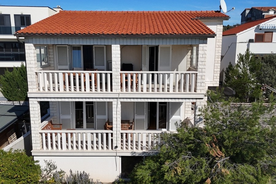 House view with terraces and red tiled roof near the coast