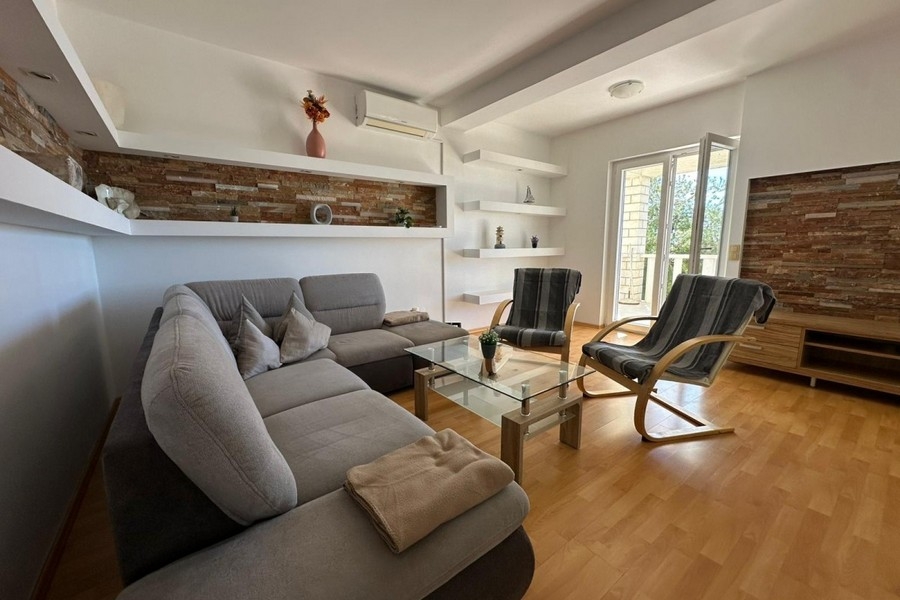 Living room with sofa, armchair and modern wall design