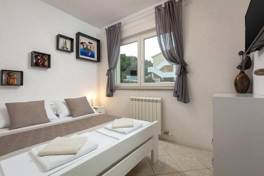 Bedroom with double bed and window with a view of the greenery