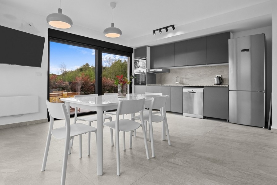 Modern living and dining area with open kitchen and access to the terrace