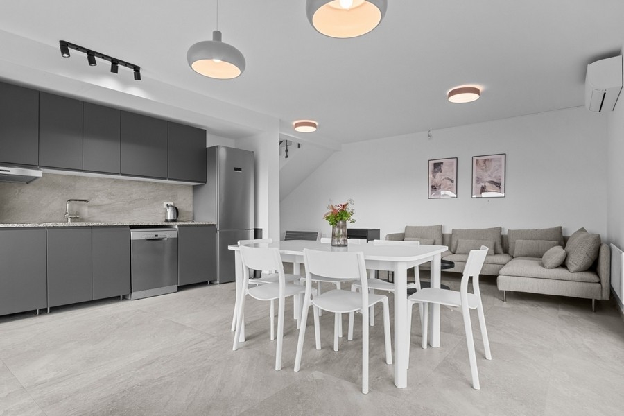 Bright living area with sofa and integrated kitchen in an open floor plan