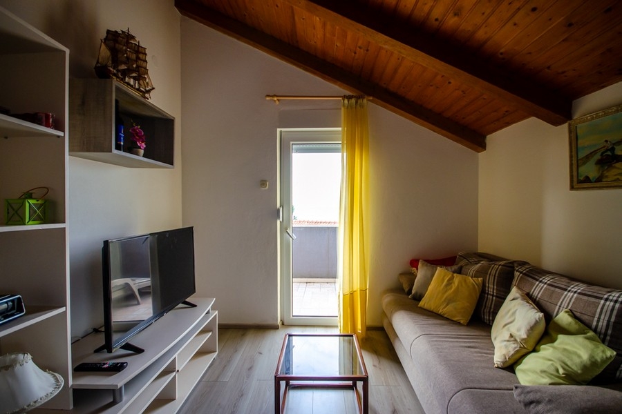 Living room in the attic with sofa and access to the balcony
