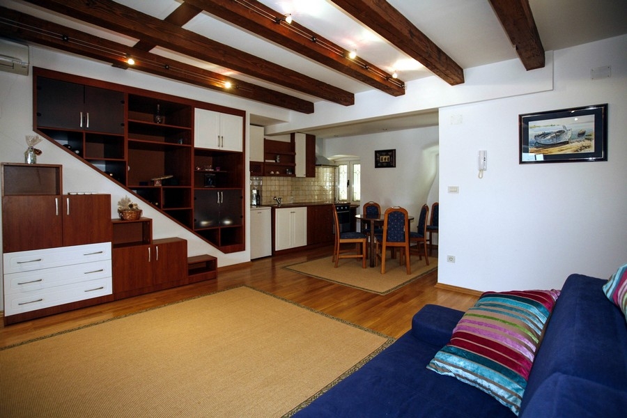 Living area with open kitchen and exposed wooden beams