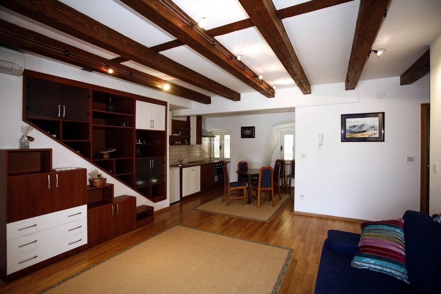 Open living room with fitted kitchen and wooden ceiling