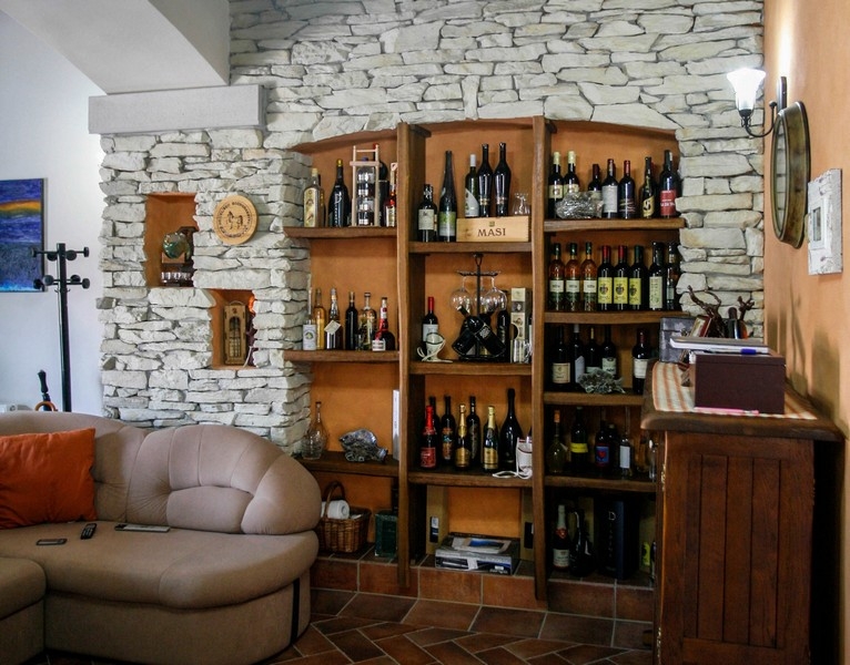 Living room with natural stone wall and integrated wine rack