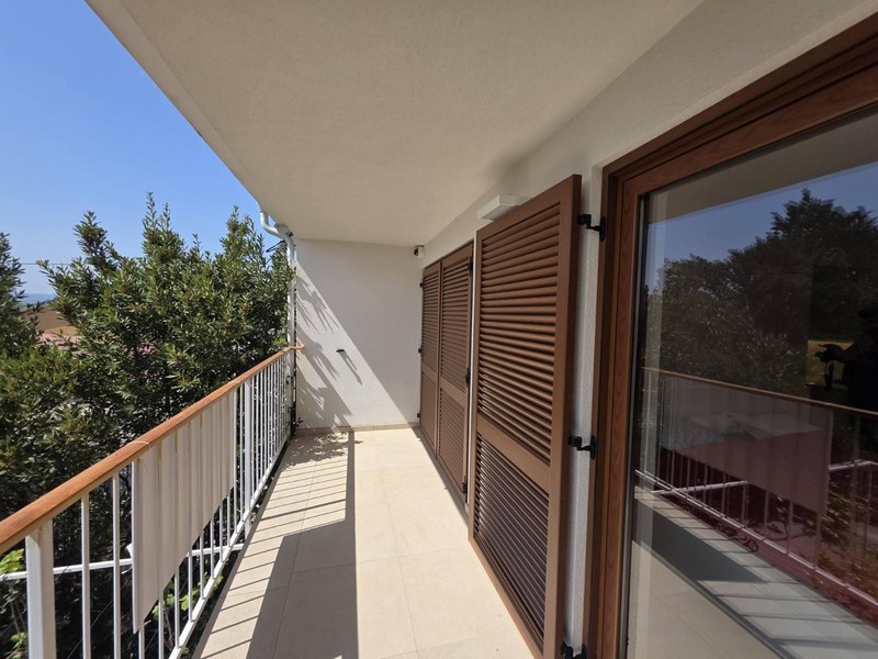 Balcony with wooden shutters and partial sea views