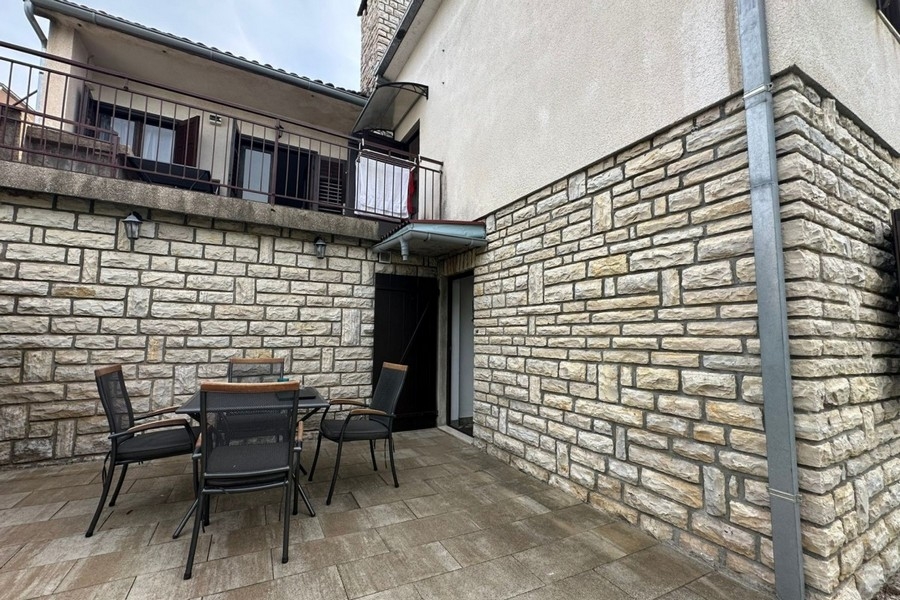 Courtyard with stone facade and terrace with seating area