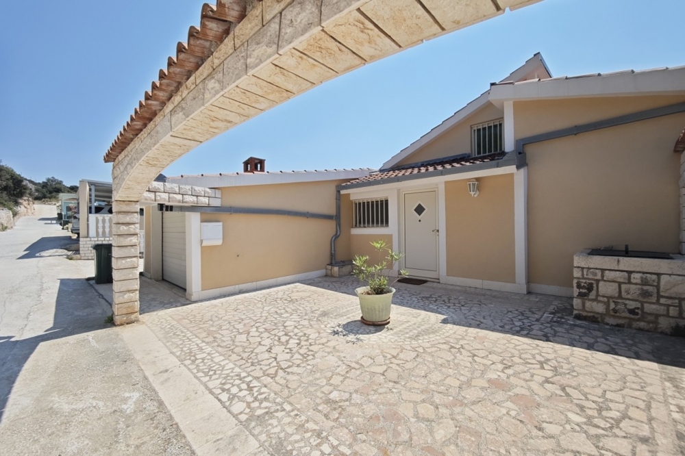 House facade with garage and paved yard