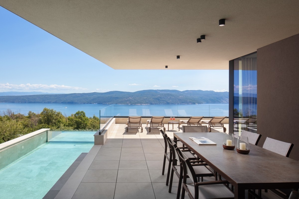 Covered terrace with dining area and sea views