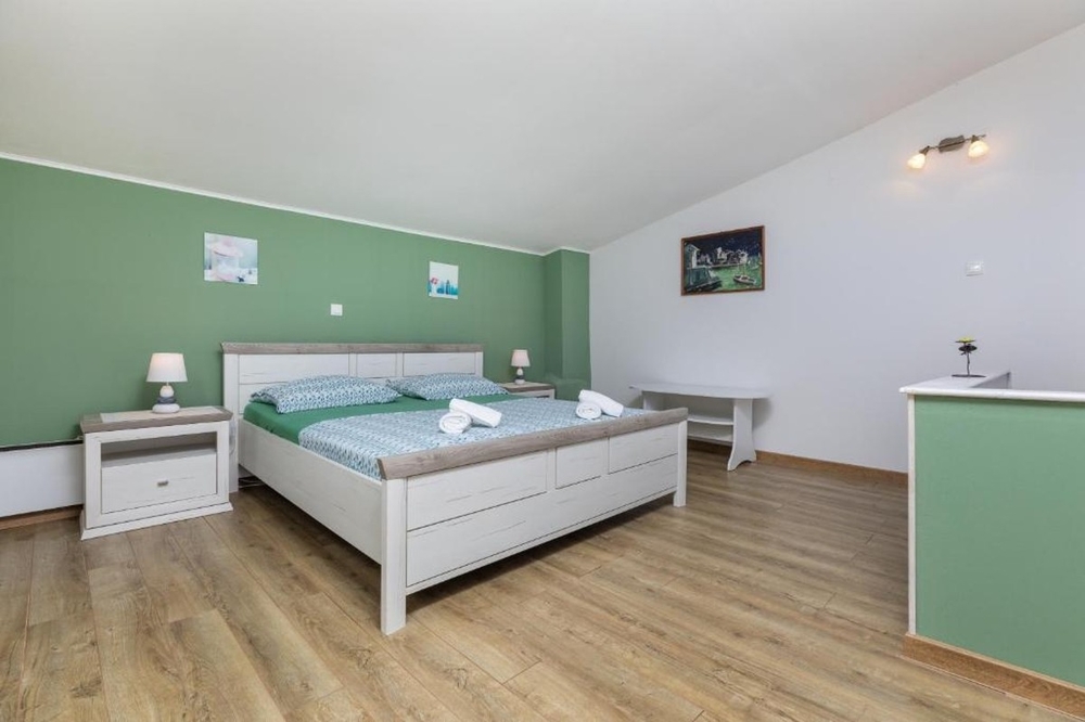 Bedroom with double bed and light wood design