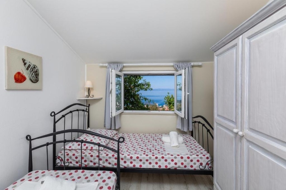 Bedroom with single beds and sea views through window