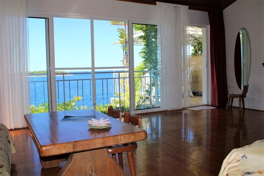 Living area with large window fronts and access to the terrace with sea views