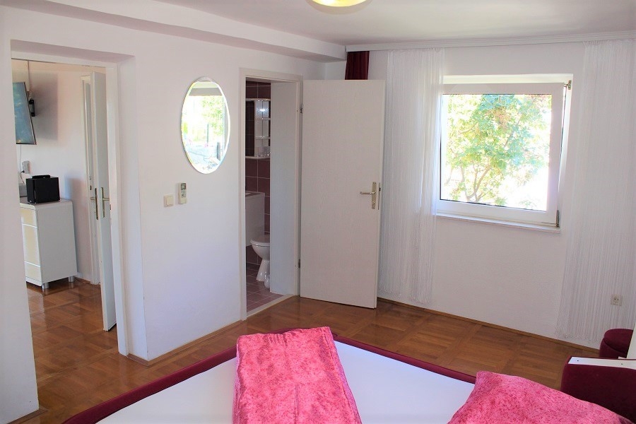 Bedroom with access to the bathroom and a view of the greenery