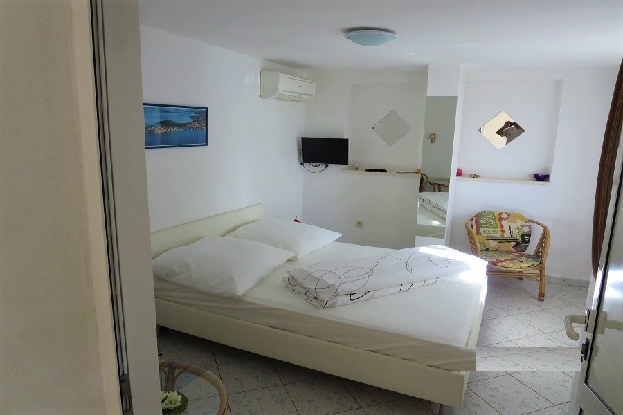 Bedroom with double bed, air conditioning and bright furnishings