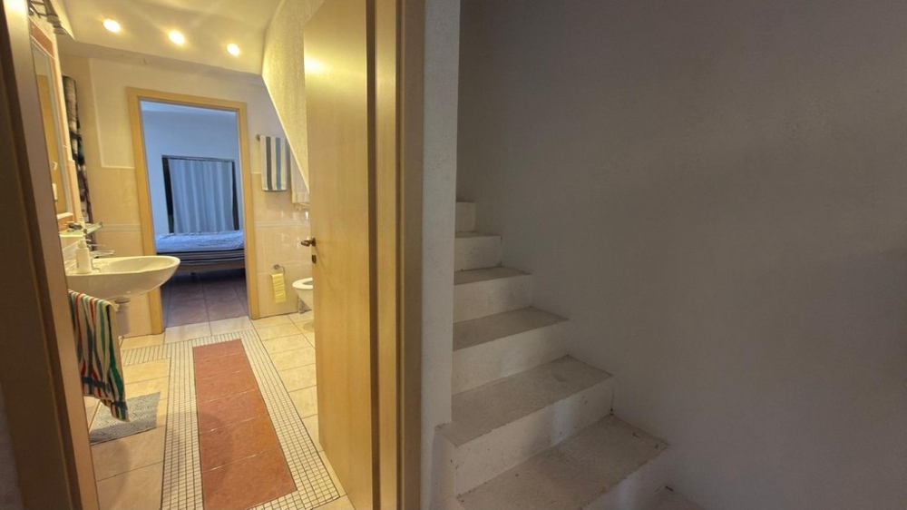Hallway with access to bathroom and stairs