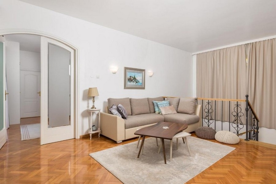 Living area on the upper floor with sofa and parquet floor